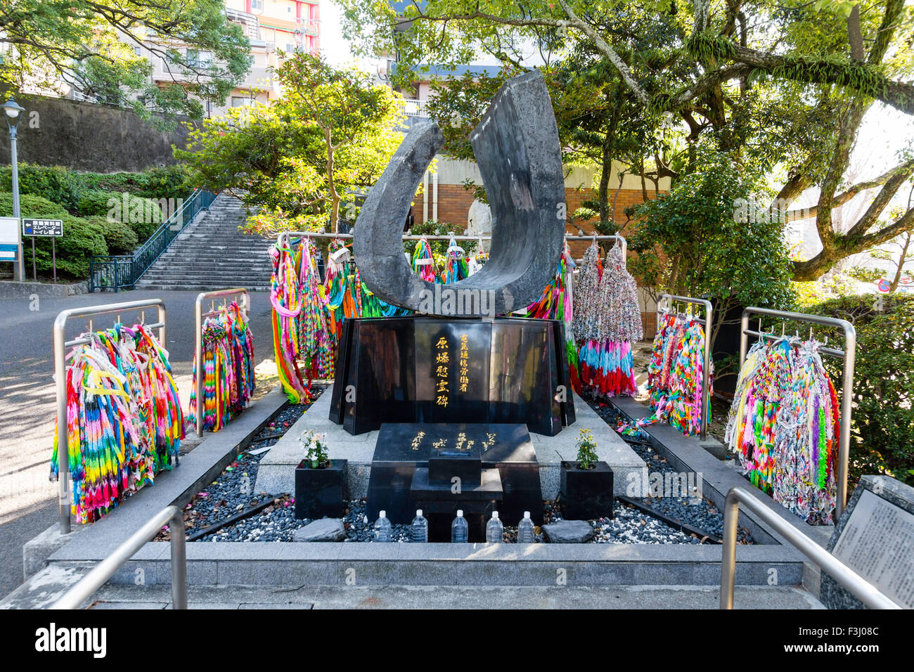 Nagasaki, the atomic bomb peace park. Paper cranes on frames around a sculpture memorial to the dead. Bottled water left as offerings. Stock Photo