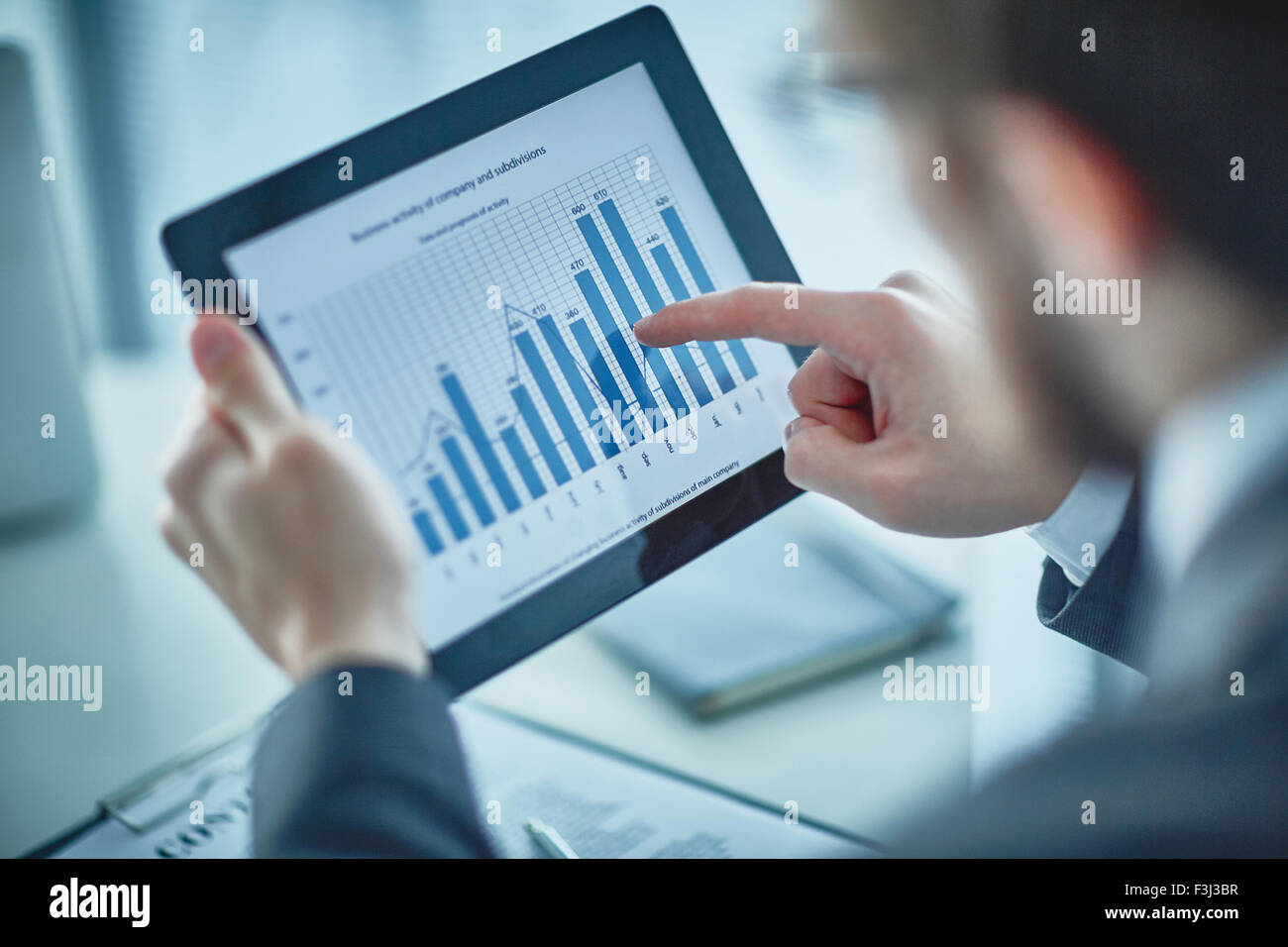 Businessman pointing at chart and graph in digital tablet Stock Photo ...
