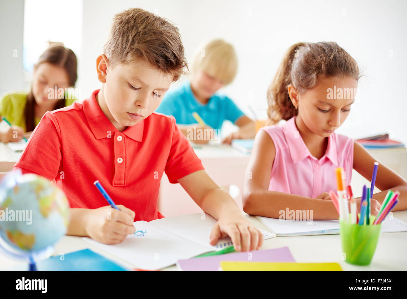 Clever pupils drawing at lesson Stock Photo - Alamy