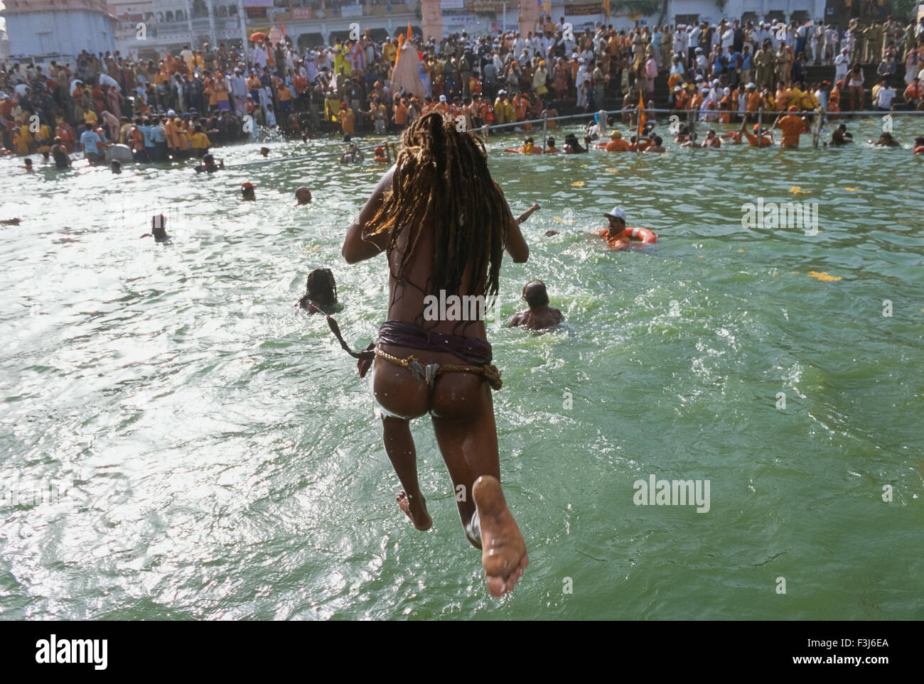 Naga (naked) sadhu jumping into the Shipra River, on the Shai Snan bathing day, Simhastha Kumbh Mela 2004, Ujjain, Madhya Pradesh, India Stock Photo