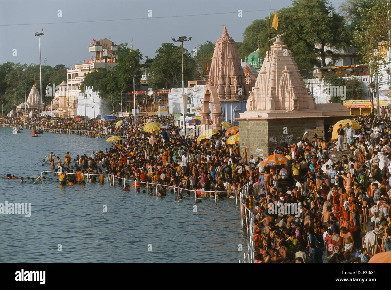 Bathing pilgrims thronging the ghats of the Shipra River during evening prayers, Simhastha Kumbh Mela 2004, Ujjain, Madhya Pradesh, India Stock Photo