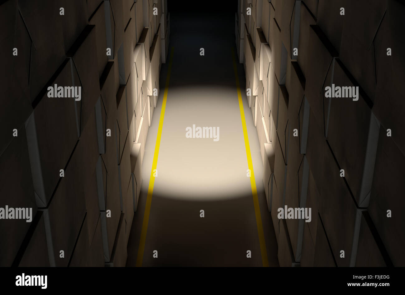A direct top view of aisle of stacked wrapped boxes in a concrete warehouse dramatically lit by a dim spotlight Stock Photo