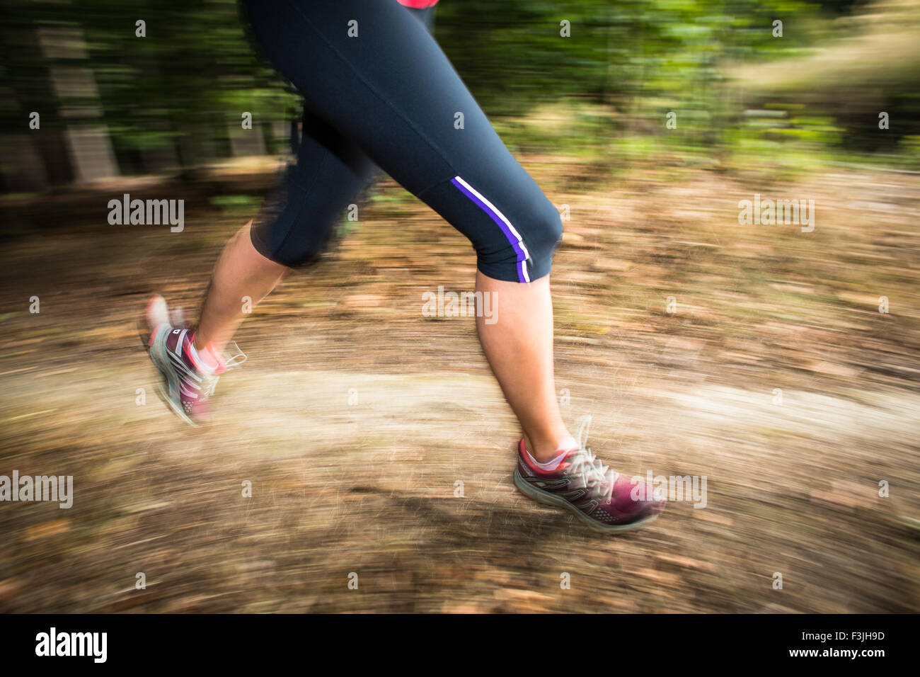Young woman running outdoors in a forest, going fast (motion blurred ...