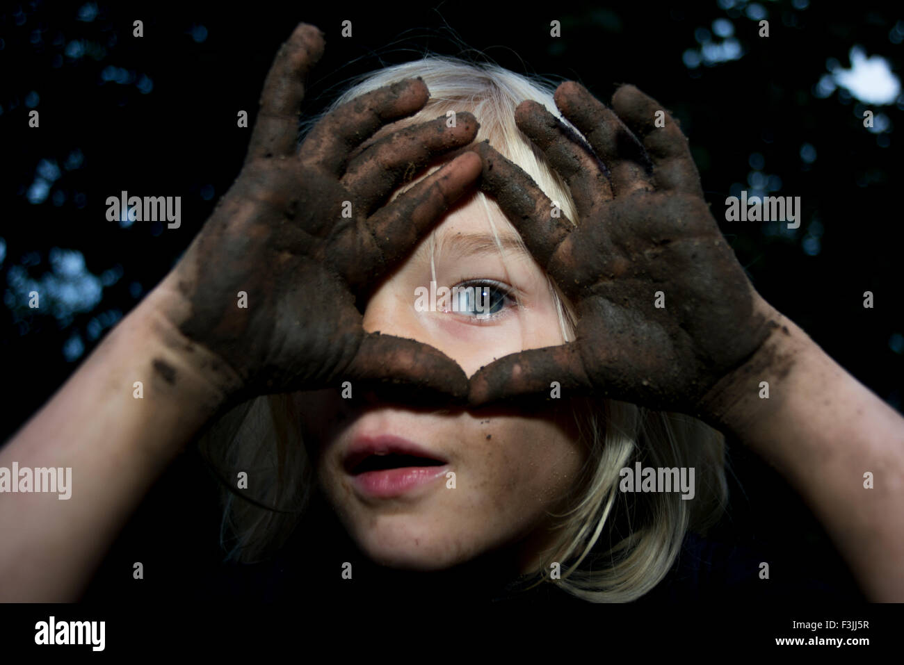 Portrait of little child blond girl showing hands full of dirt Stock Photo