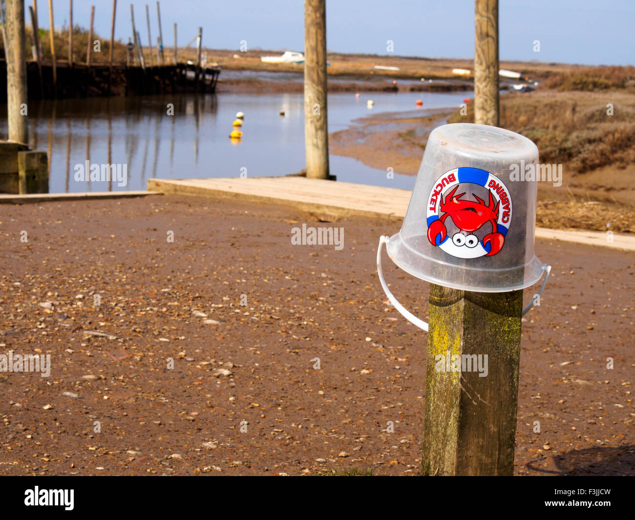 A clear plastic crabbing bucket upside down on a post in Blakeney, Norfolk. Stock Photo
