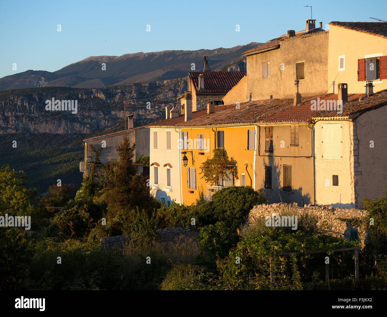 Sunset light on old houses in the village of Aiguines, Var, Provence, in Southern France. The mountains of the Verdon Gorge behind. Stock Photo