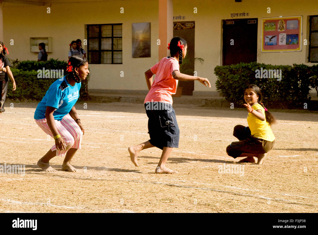 School children playing tag game of Kho Kho at Shivkar Village Panvel taluka Maharashtra India Stock Photo