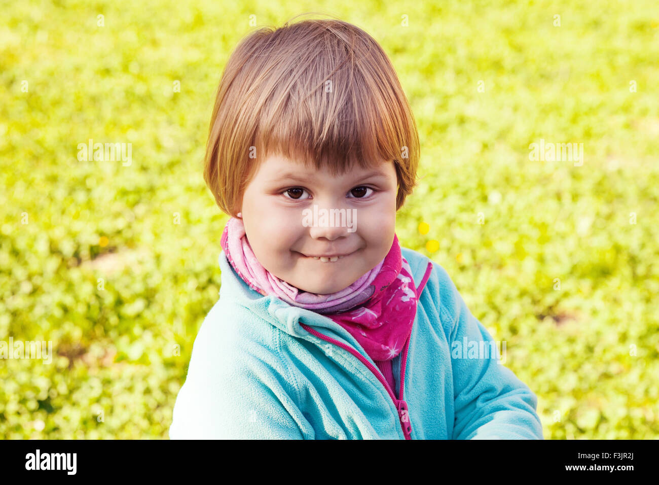 Outdoor portrait of cute smiling Caucasian blond baby girl walking in a ...