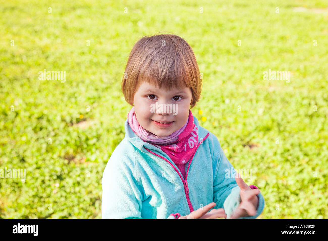 Outdoor portrait of cute smiling Caucasian blond baby girl walking in ...