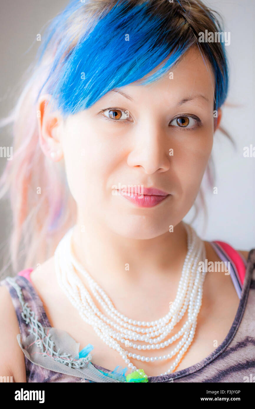 Premium Photo  Lovely girl with blue hair and pearls around her neck  looking at the camera