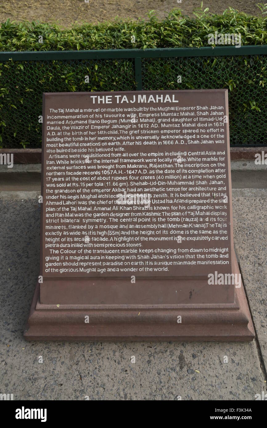 The explanation detail monument information board white text on red stone at the entrance to the Mughal Taj Mahal Agra India Stock Photo