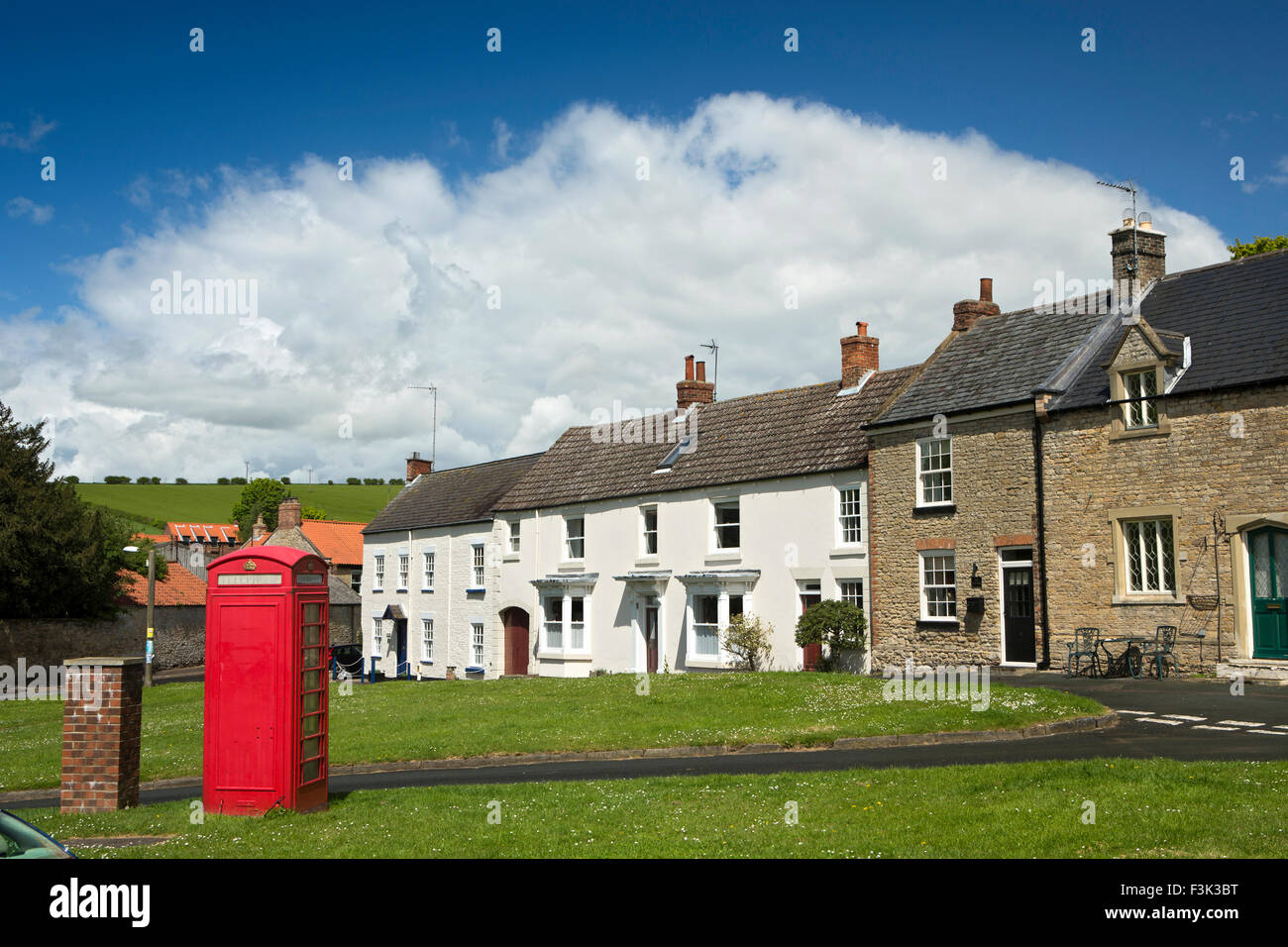 UK, England, Yorkshire East Riding, North Newbold, phone box and houses around village green Stock Photo