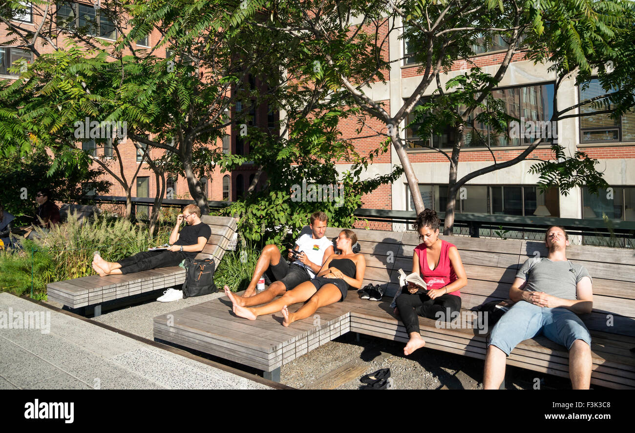 Men and women relaxing on wooden chaise lounge in the sunshine on High