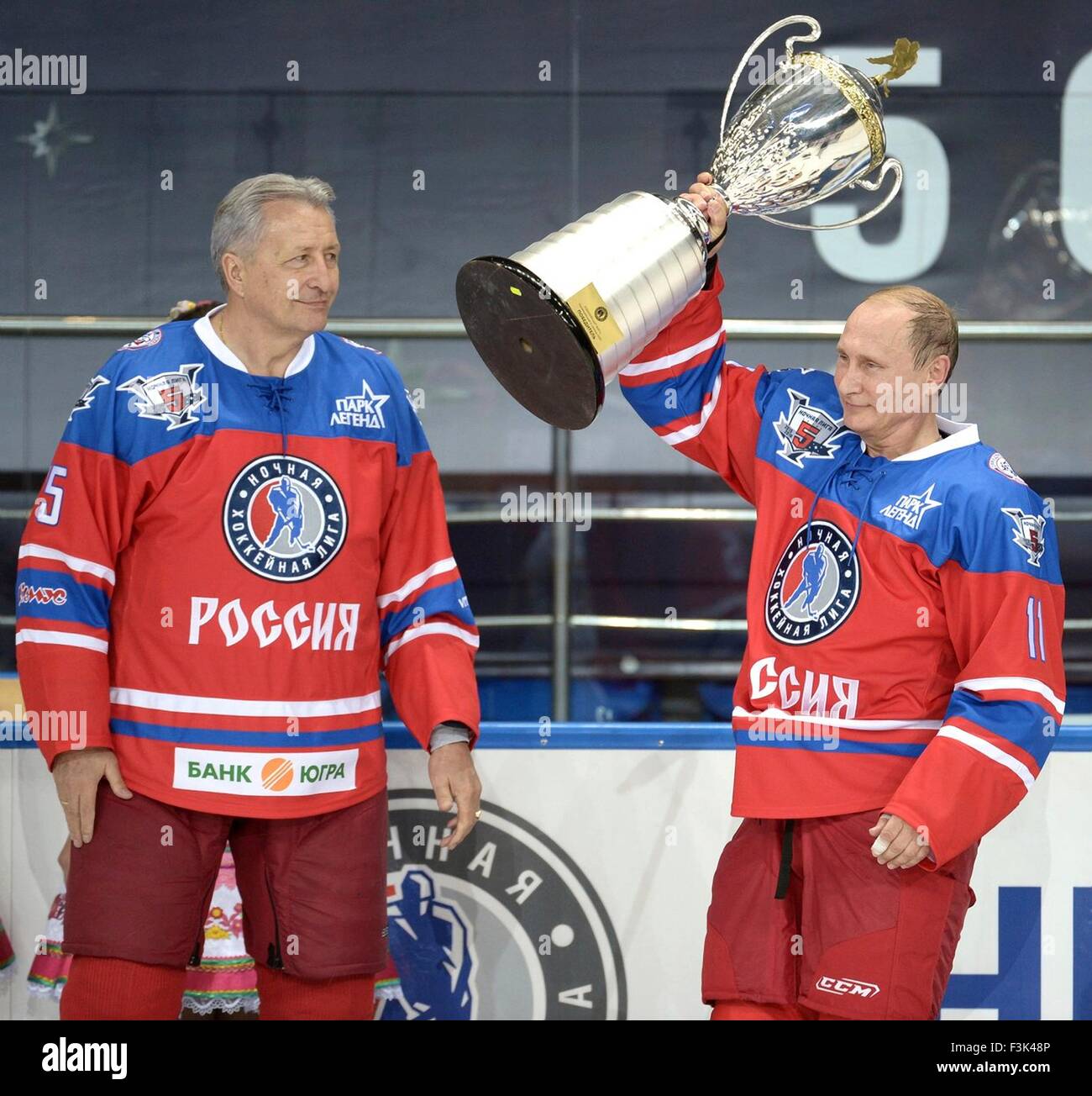 Russian President Vladimir Putin holds a trophy as Alexander Yakushev looks on after an ice hockey match between former NHL stars and Russian government officials at the Shayba Arena October 7, 2015 in Sochi, Russia. The game took place on Putin's 63rd birthday. Stock Photo