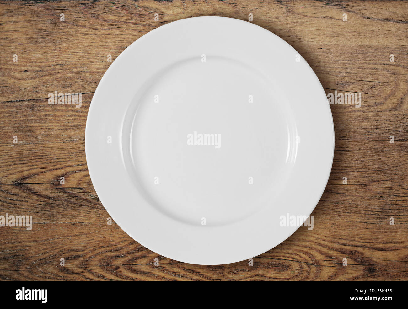 white dinner plate on wooden table top view Stock Photo