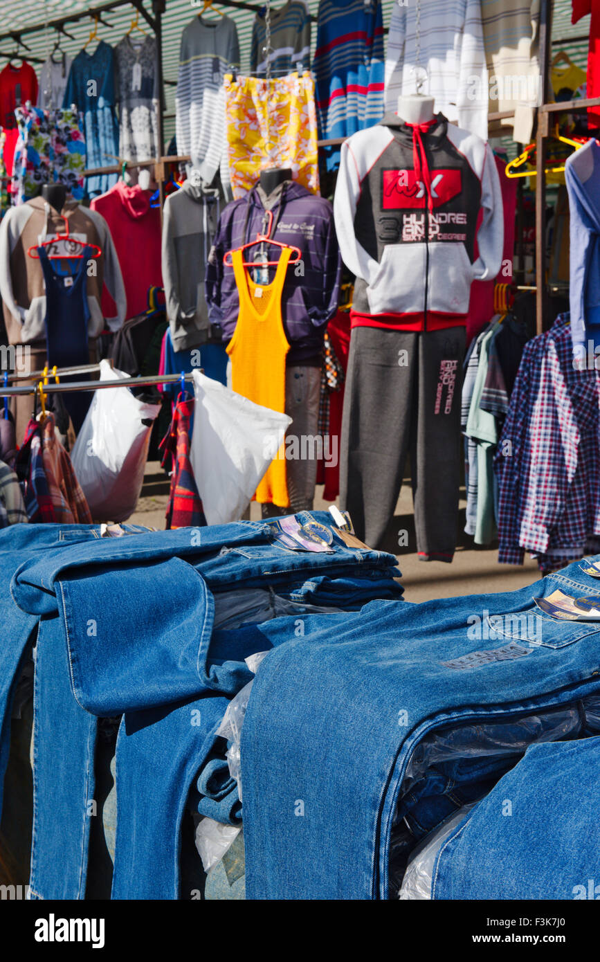 Blue denim jeans and other clothing in outdoor market stall, Bristol, England Stock Photo