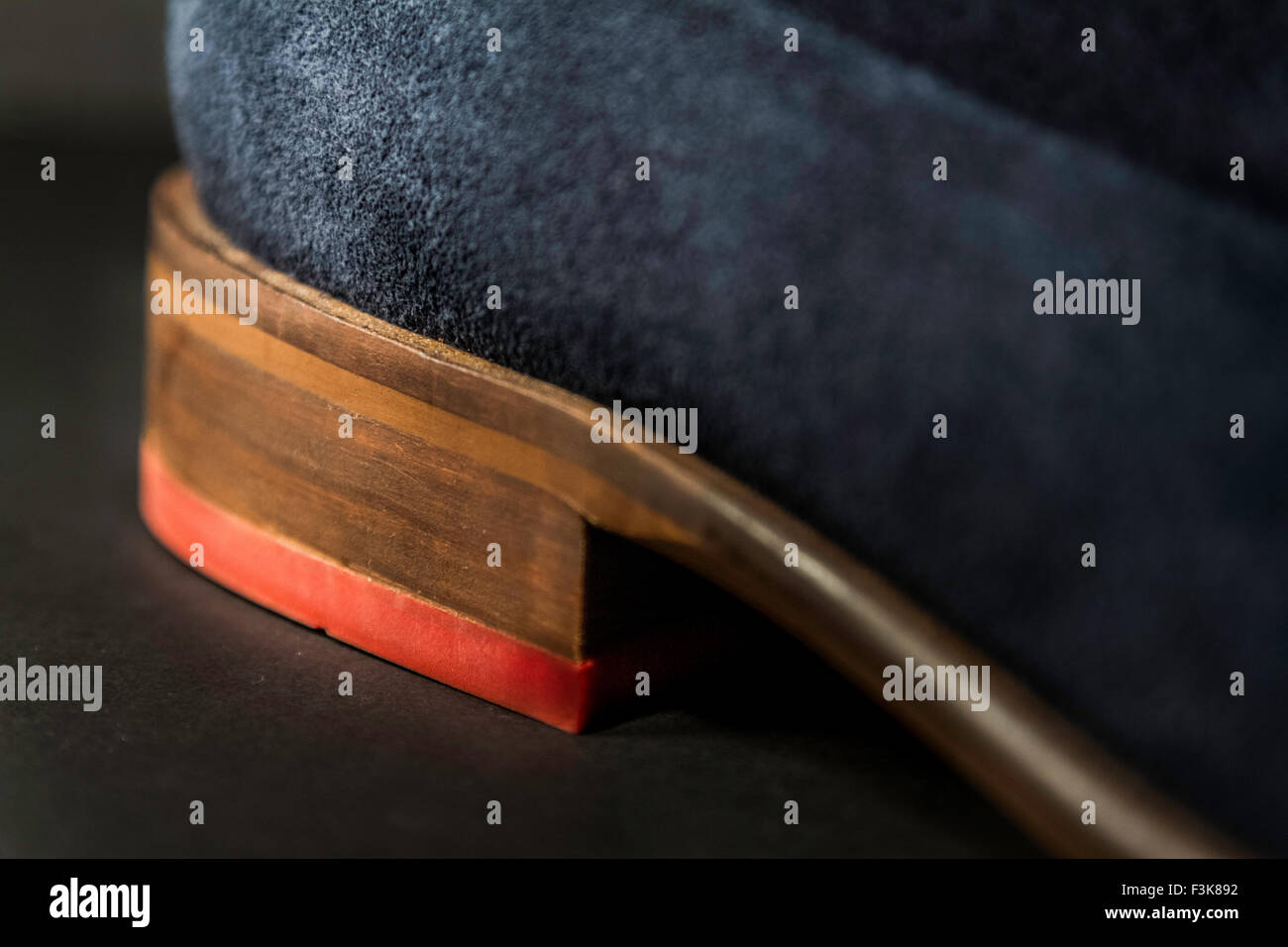 A beautiful shot of the heel of a blue suede shoe, with highlighted red heels Stock Photo