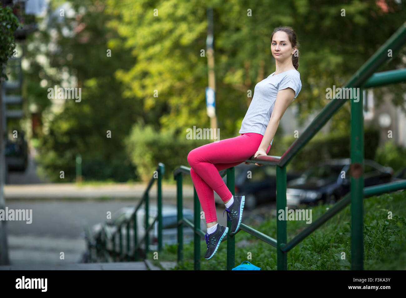 Resting On Railing Young sporty girl sitting resting on the railing in the Park Stock ...