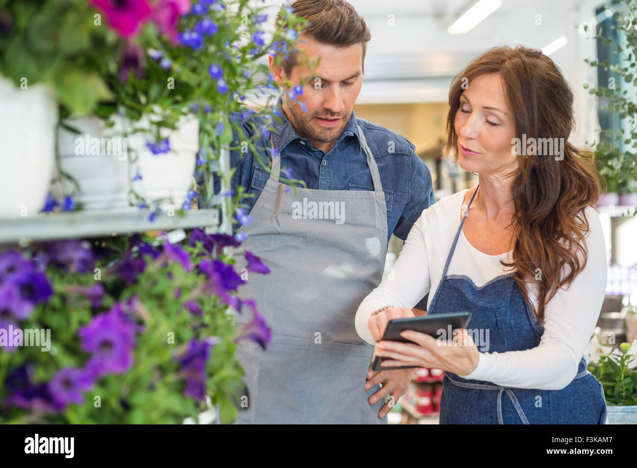 Florists Using Digital Tablet In Flower Shop Stock Photo