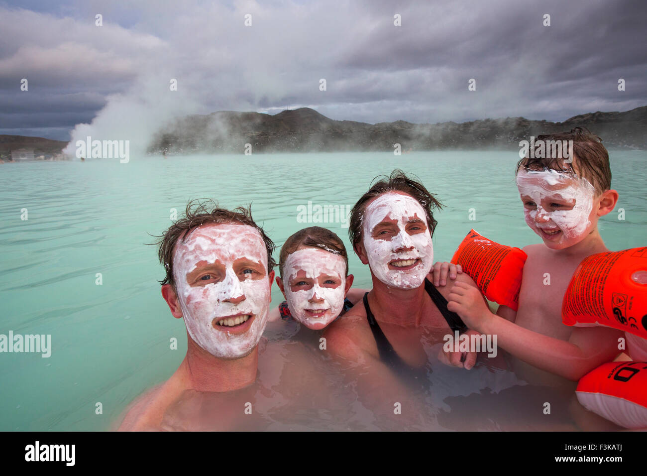 Family with silica mud face masks swimmning at the Blue Lagoon geothermal spa. Grindavik, Iceland. Stock Photo