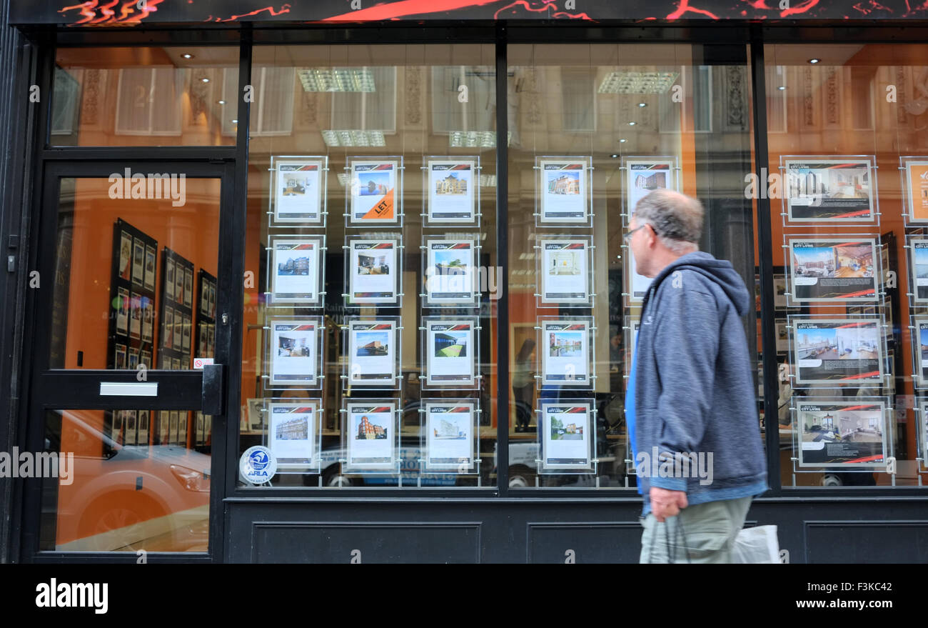 A man looking into a real estate agents shop window to view properties for sale. Housing information, accommodation in Liverpool, Merseyside, UK Stock Photo
