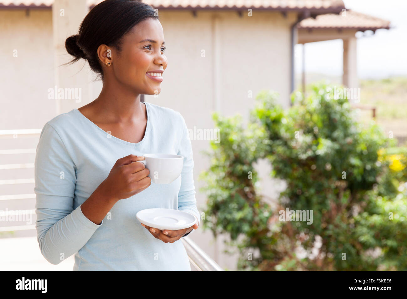 pretty African American woman drinking coffee on balcony Stock Photo ...
