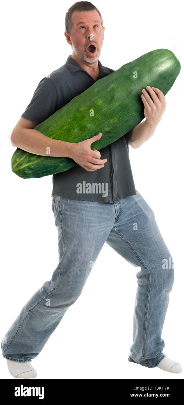 Adult caucasian male playing cucumber like a guitar and singing Stock Photo
