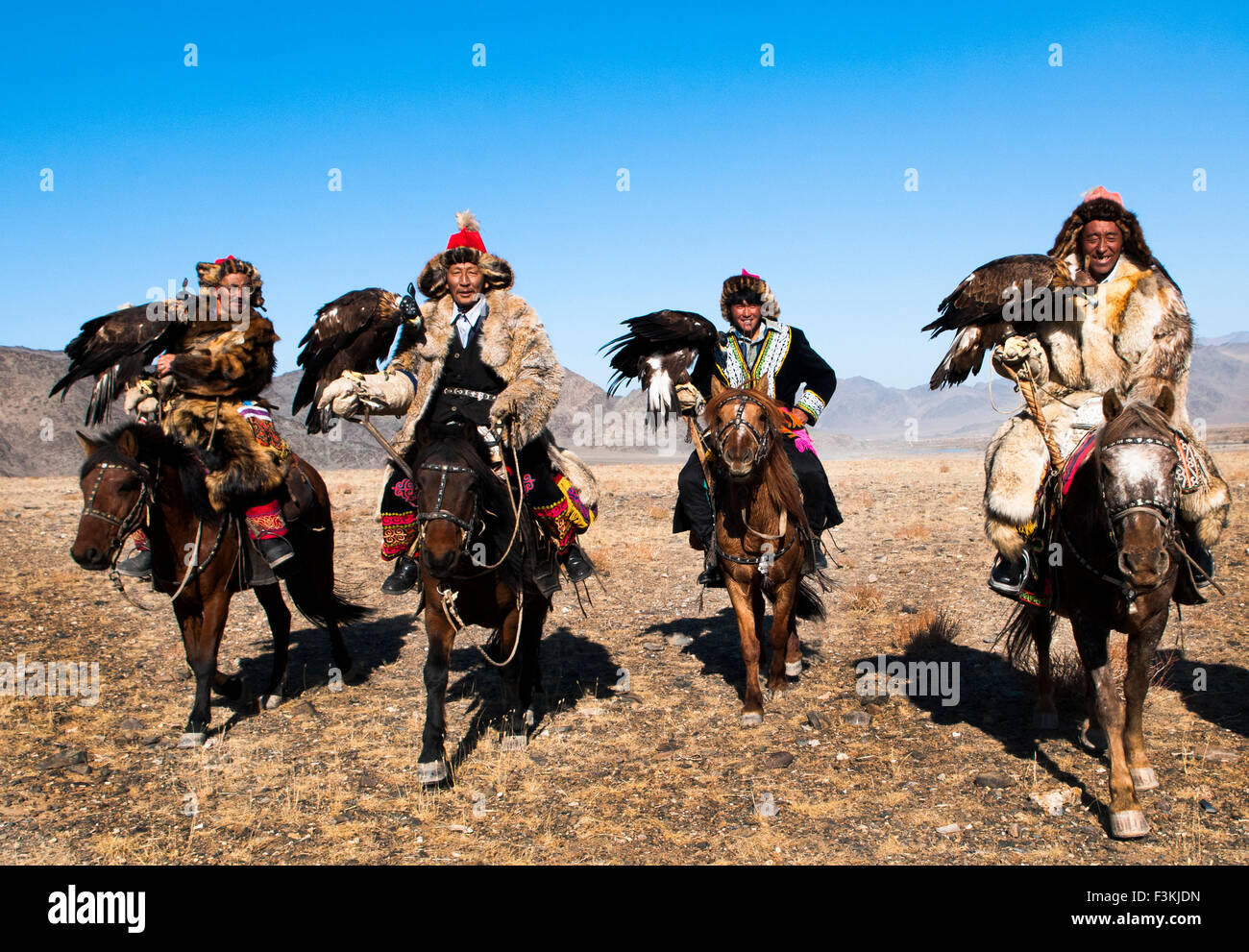Kazakh eagle hunters and their golden eagles in the Altai Region of Bayan-Ölgii in Western Mongolia. Stock Photo