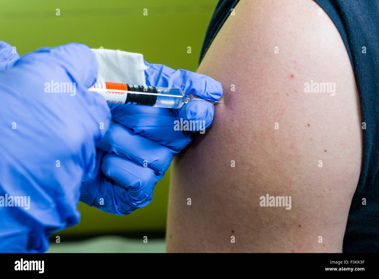Water Injection Hand A injection of fluid medicine into a patients arm is done by two hands ...