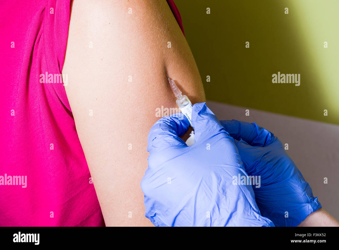 Water Injection Hand A injection of fluid medicine into a patients arm is done by two hands ...