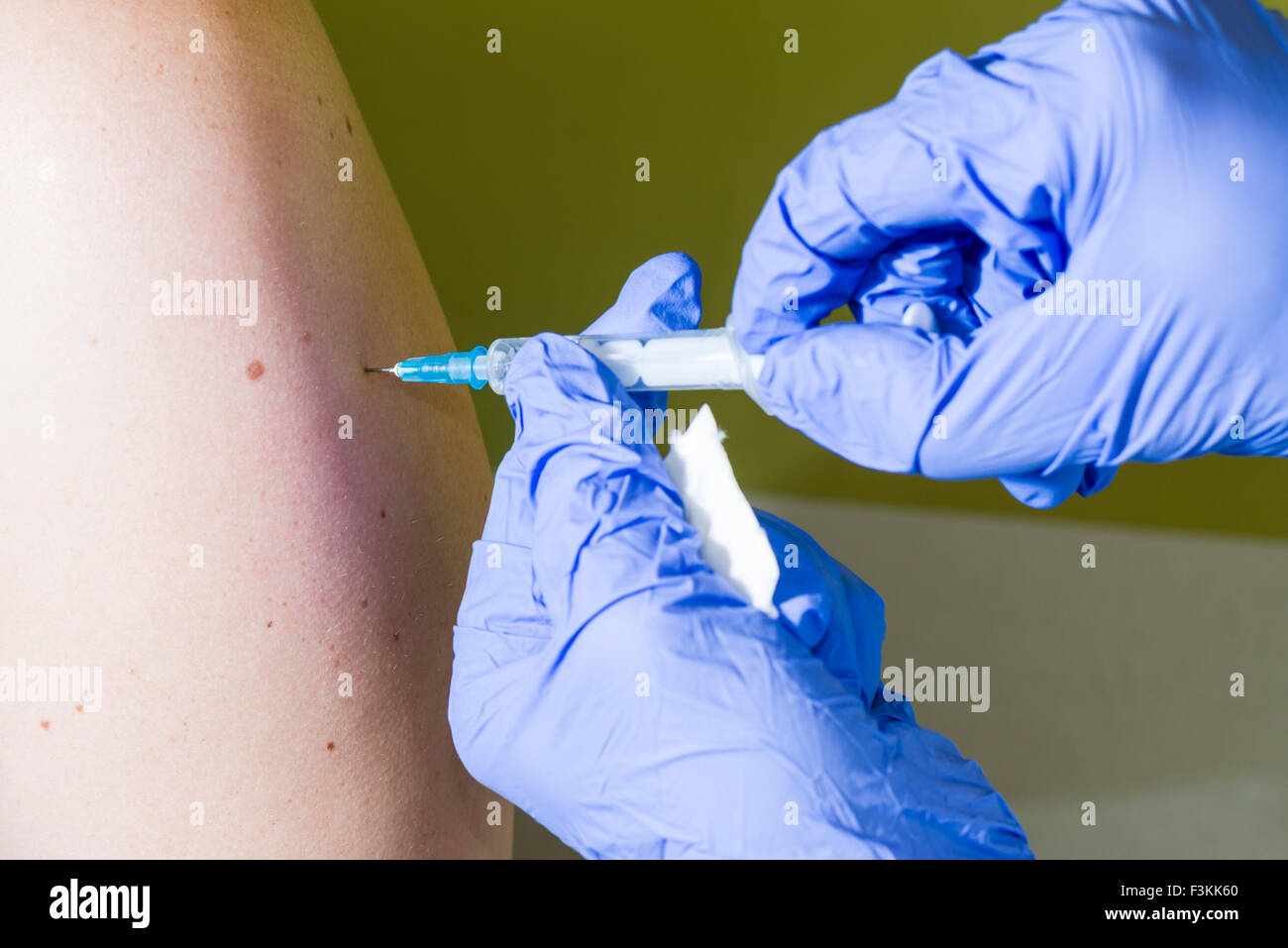 Water Injection Hand A injection of fluid medicine into a patients arm is done by two hands ...