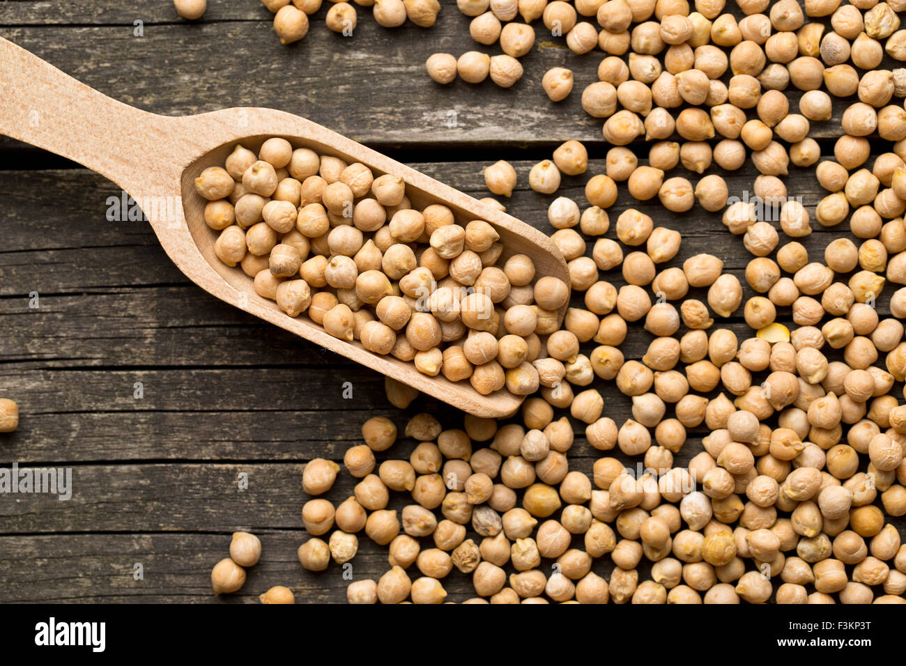 uncooked chickpeas in wooden scoop Stock Photo