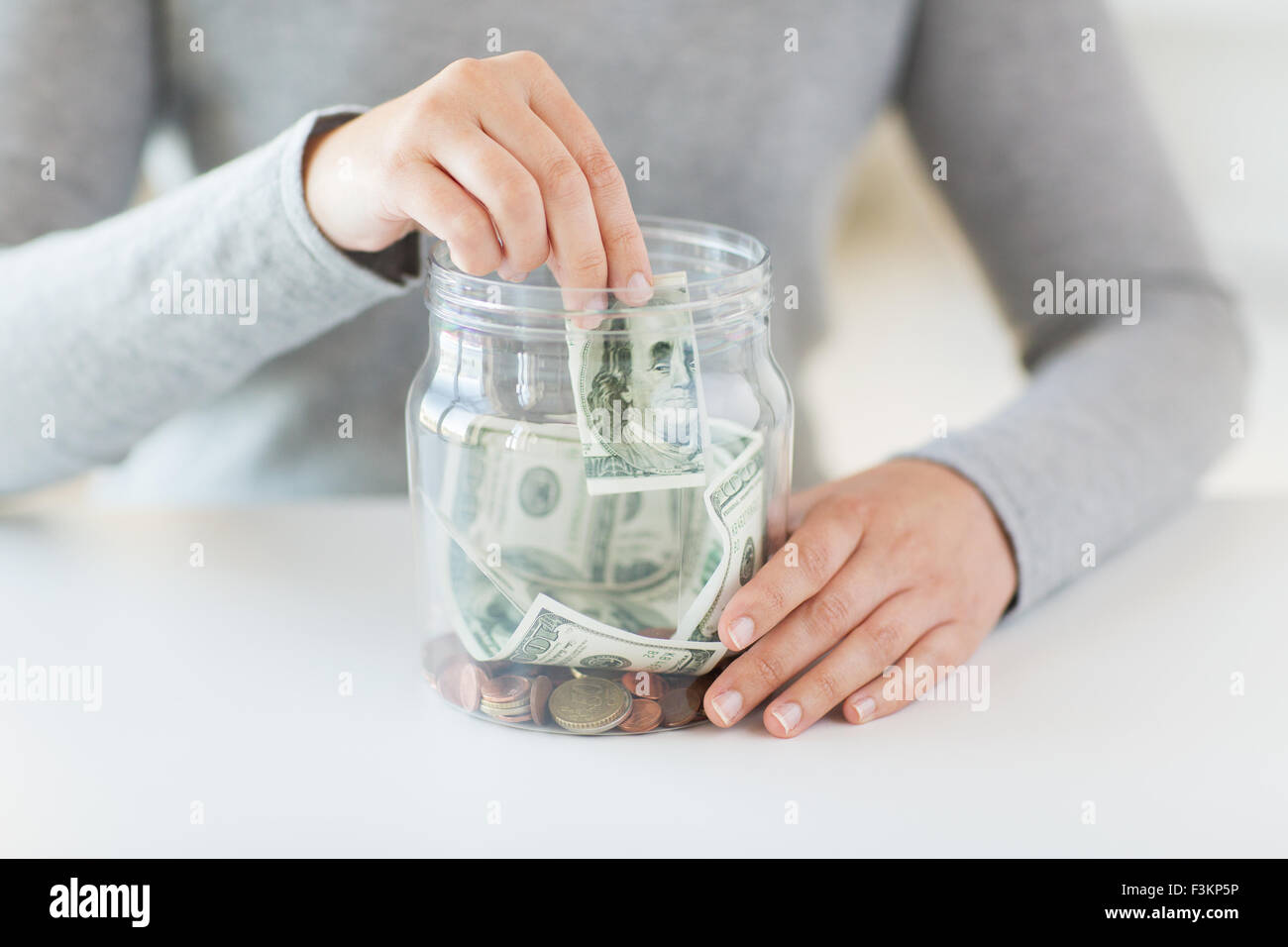 close up of woman hands and dollar money in jar Stock Photo