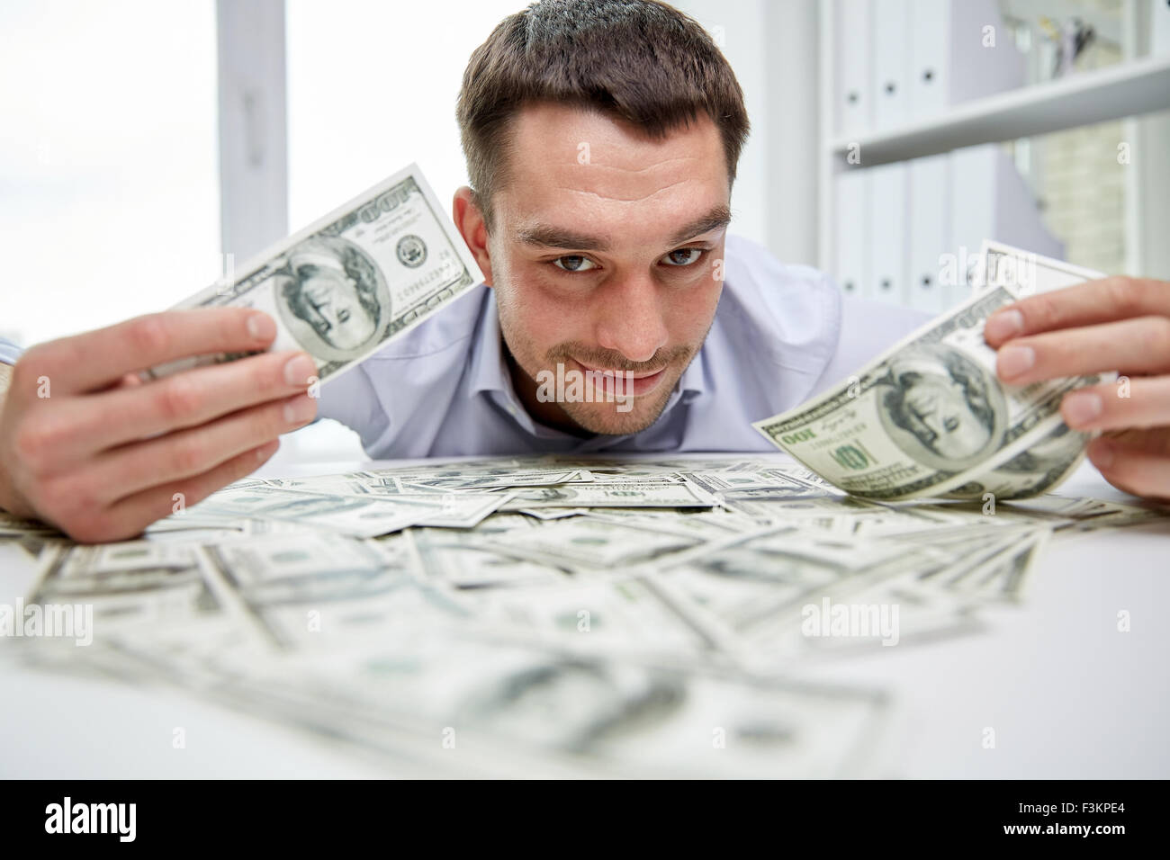happy businessman with heap of money in office Stock Photo - Alamy