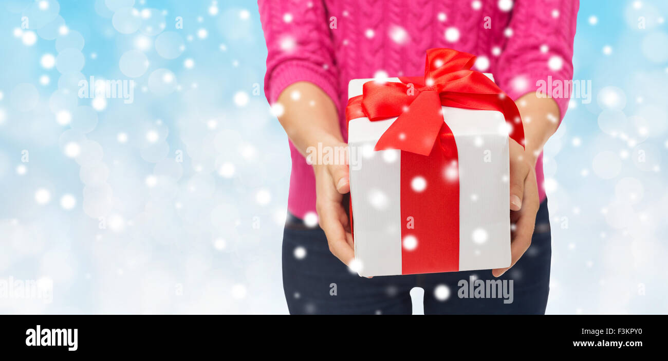 close up of woman in pink sweater holding gift box Stock Photo