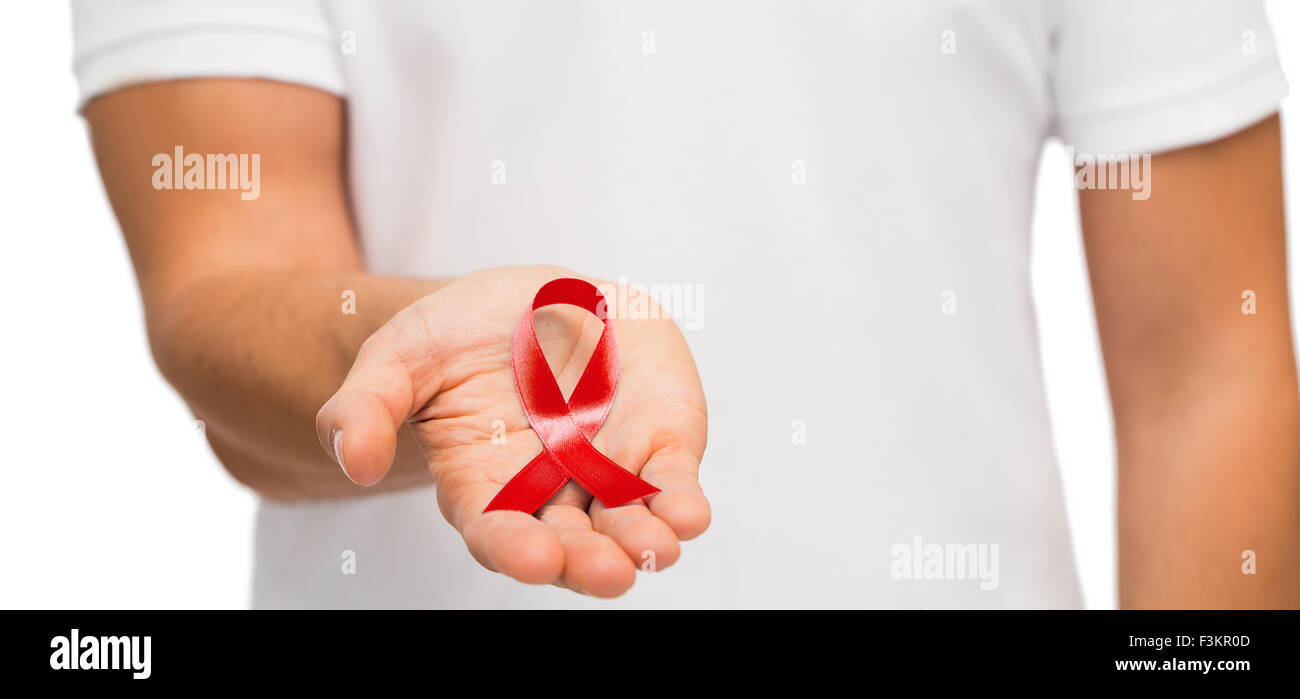 hand with red aids or hiv awareness ribbon Stock Photo