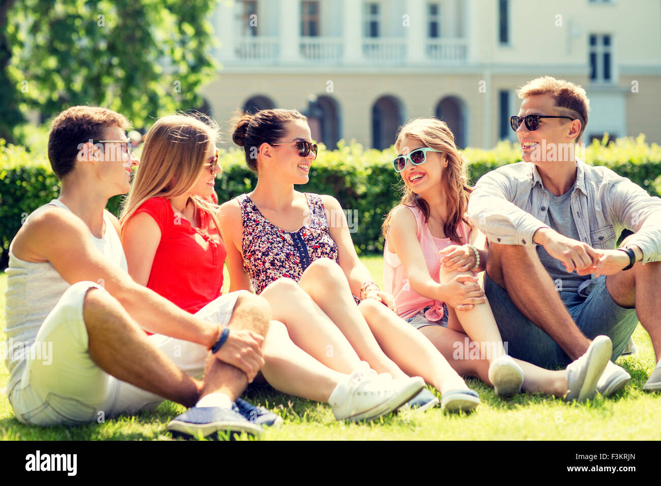 group of smiling friends outdoors sitting on grass Stock Photo - Alamy