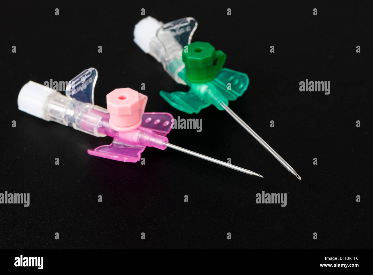 A pink an a green safety IV catheter with injection port for medical