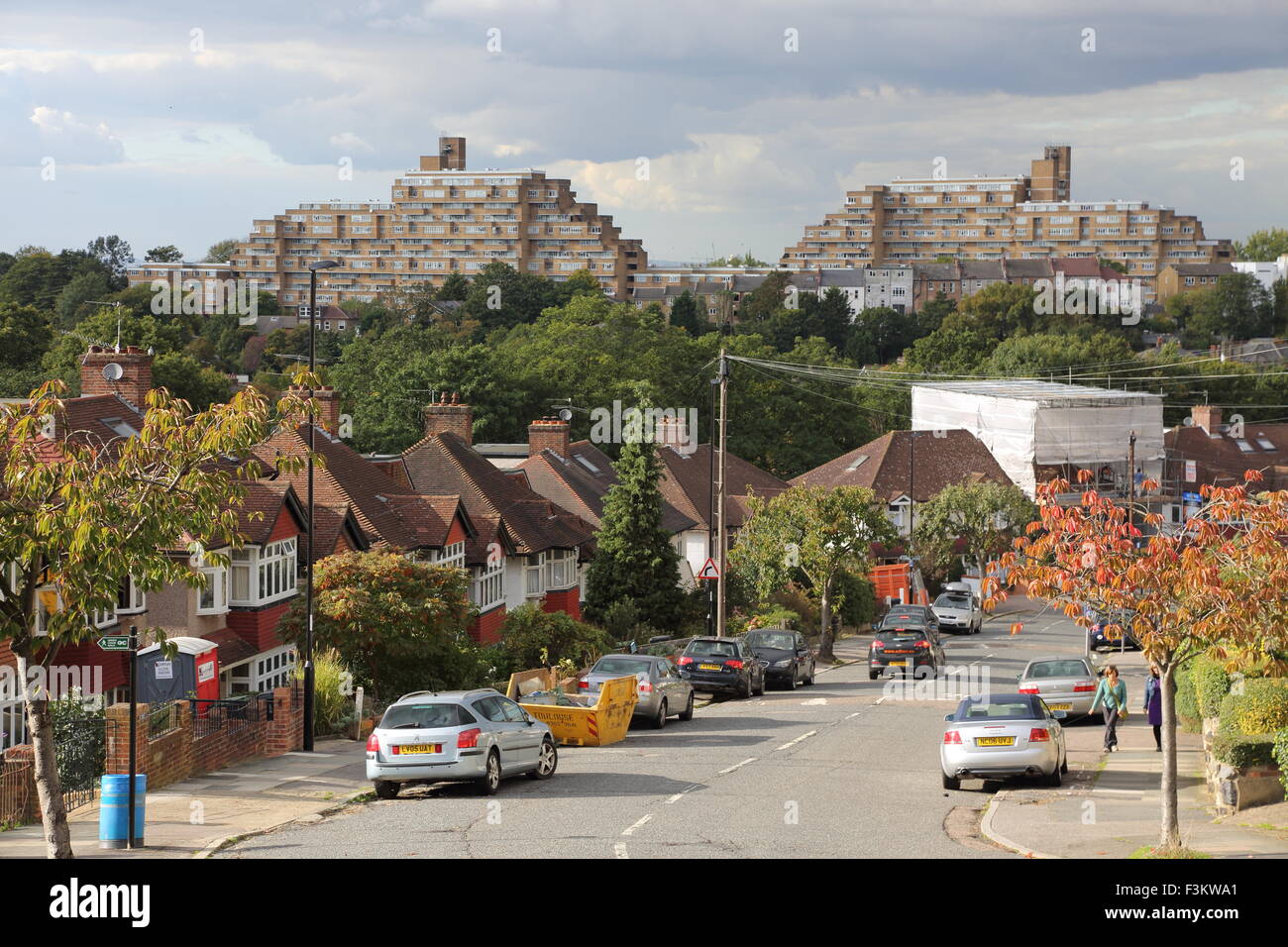 Suburban street in South East London showing the famous brutalist Dawson Heights 1960's housing scheme in the background Stock Photo