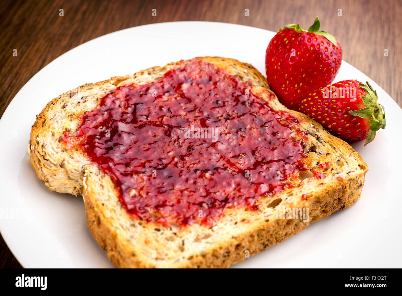 Macro closeup of delicious strawberry jam on whole wheat toast Stock Photo