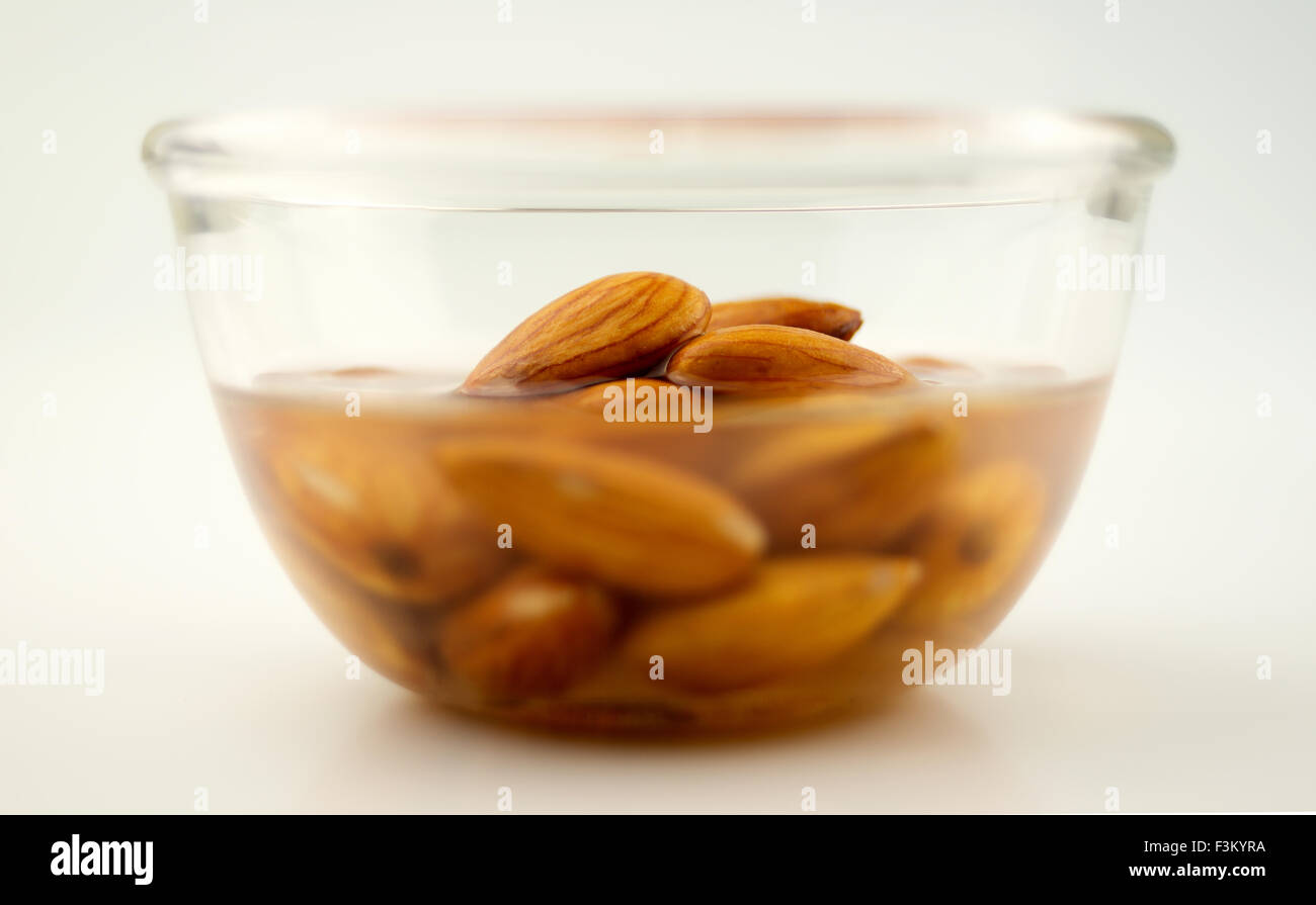 Almonds being soaked in a clear bowl, isolated on white Stock Photo Alamy