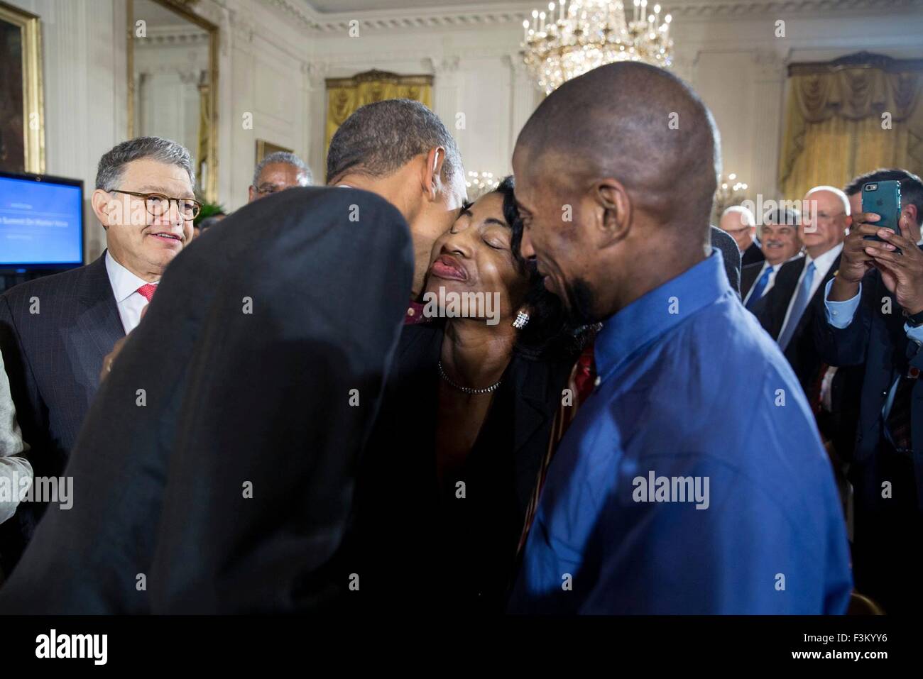 Washington DC, USA. 7th October, 2015. U.S. President Barack Obama gives Joann Wise a kiss after her son Terrence (right) introduced the president at the White House Summit on Worker Voice in the East Room October 7, 2015 in Washington, DC. The Wise family are multiple generations of fast food workers and are now organizing workers to push for higher wages. Stock Photo