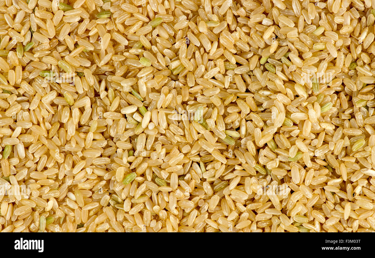 Overhead macro shot of uncooked raw brown rice background texture Stock Photo