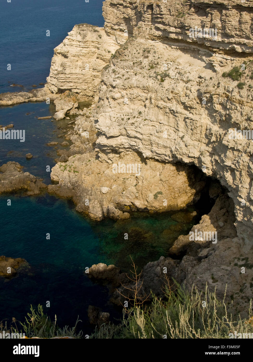 Sea landscape - rock on shore with cave in water, recorded in place Tarhankut in Crimea. Stock Photo