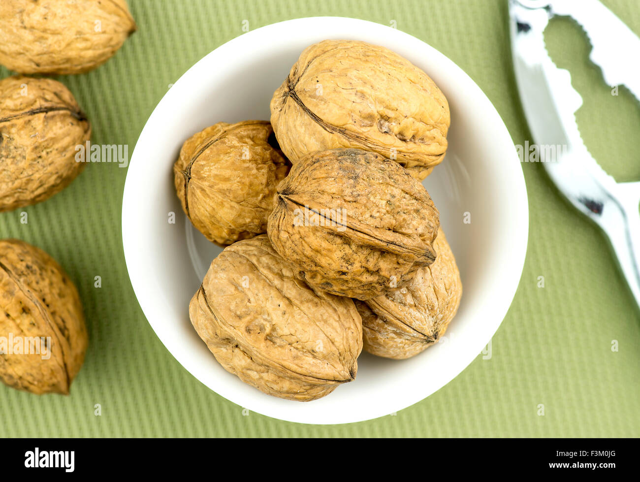 Walnuts in bowl with nut cracker nearby Stock Photo Alamy