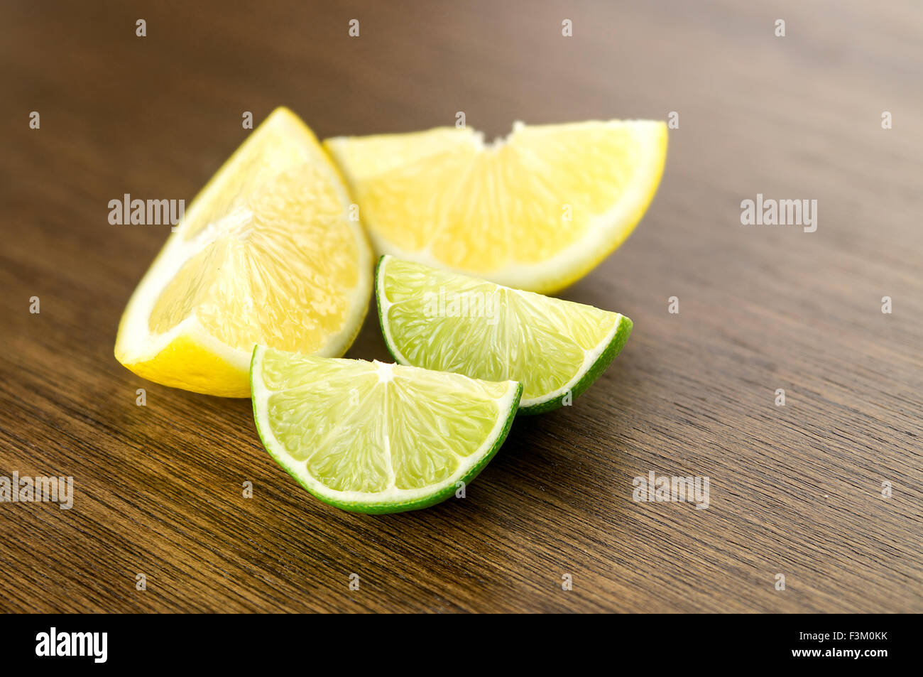 Juicy lemons and limes, cut and diced, on bar counter for drinks Stock Photo