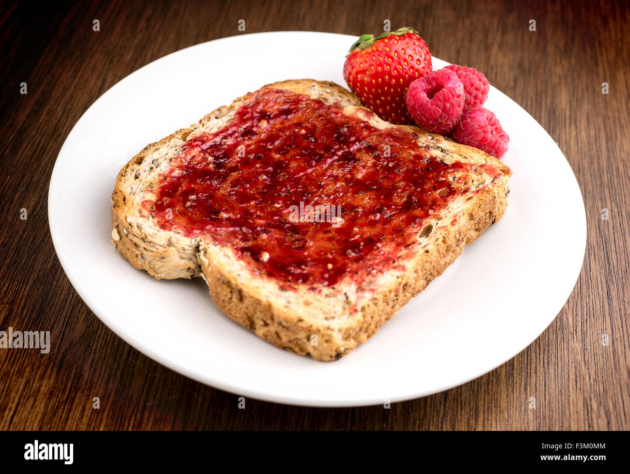 Mixed fruit jam on healthy whole wheat multi grain toast Stock Photo