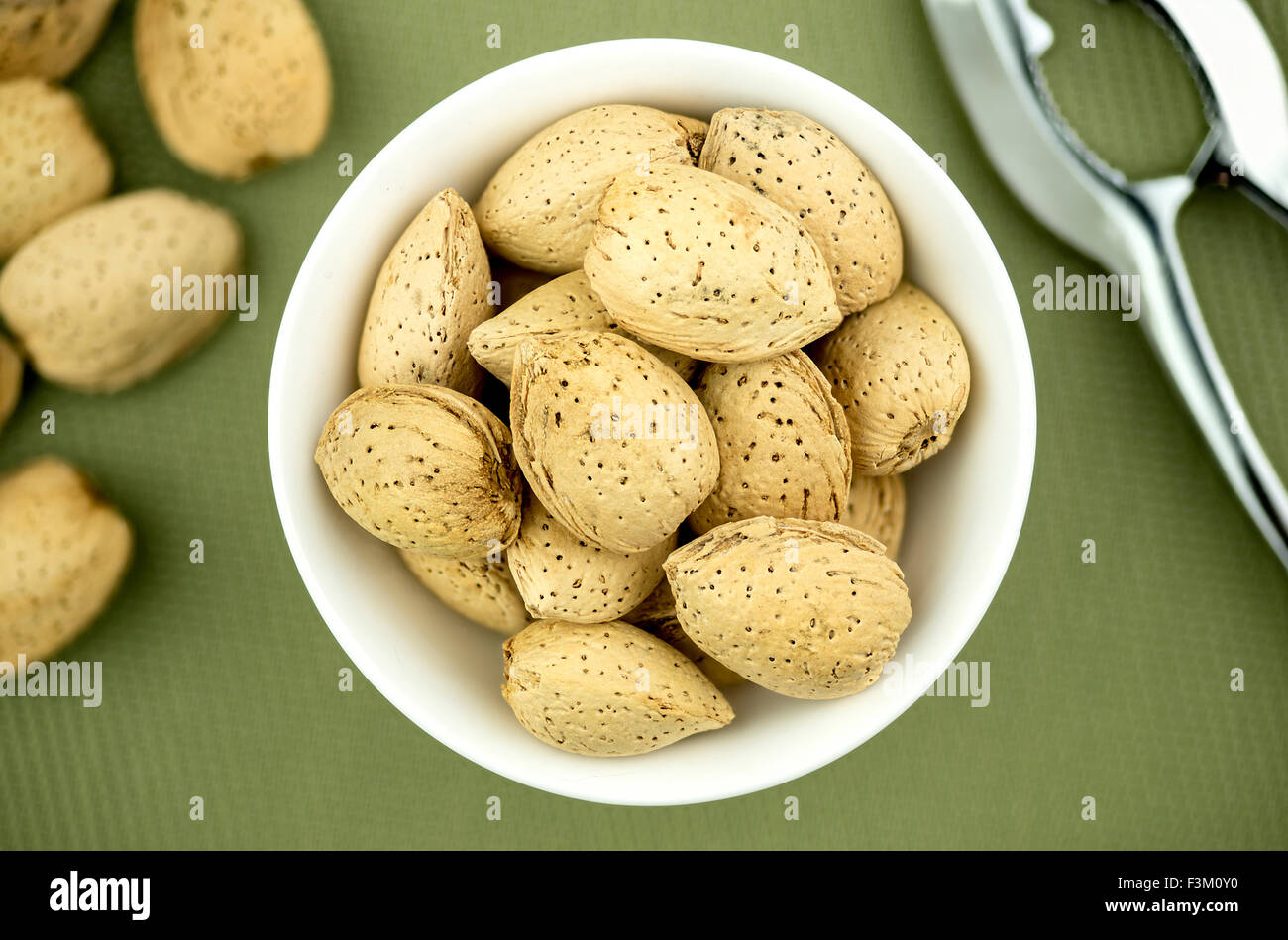 Un-shelled almonds in bowl with nutcracker Stock Photo - Alamy