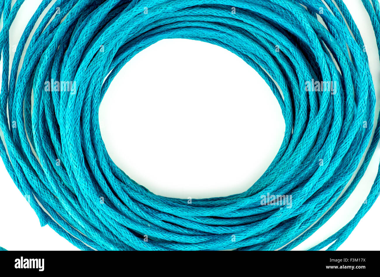 Circular loops of bright blue rope wire isolated against white with copyspace Stock Photo