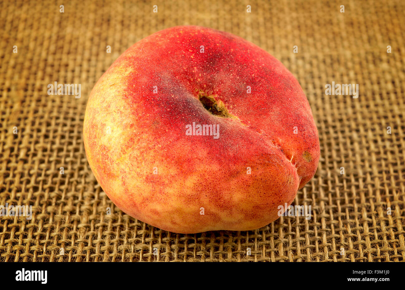 Rustic shot of flat saucer doughnut peach fruit Stock Photo